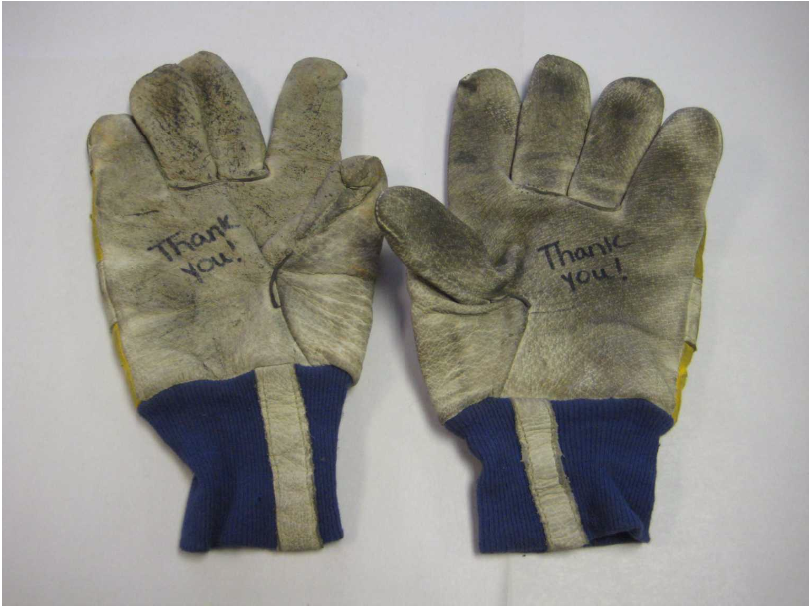 The gloves used by Det. David Brink during the rescue and recovery operations at Ground Zero following 9/11. These gloves were donated by an unknown stranger who wrote "Thank you!" on the gloves. - Photo Courtesy of 9/11 Memorial & Museum